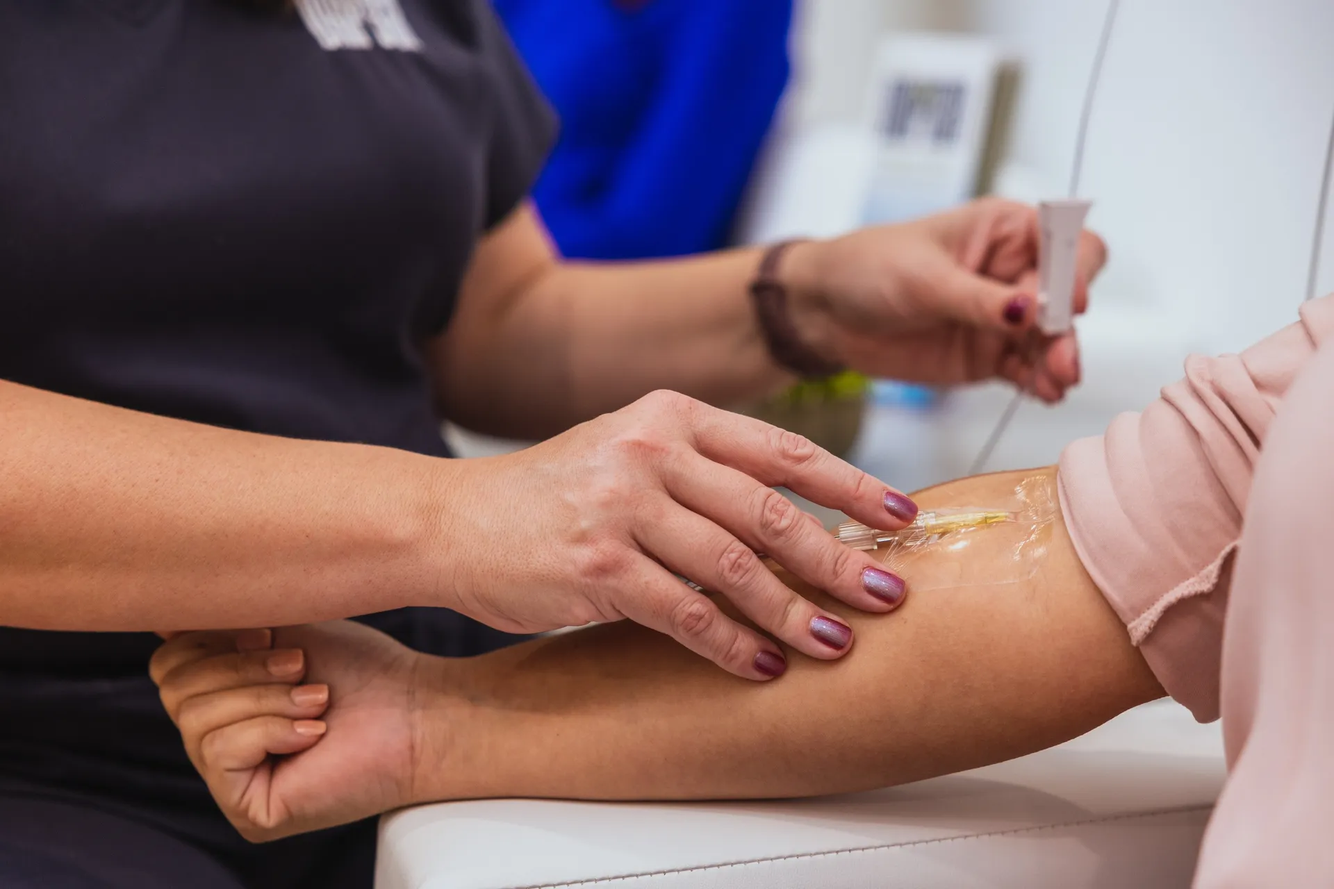 A nurse taping an IV line