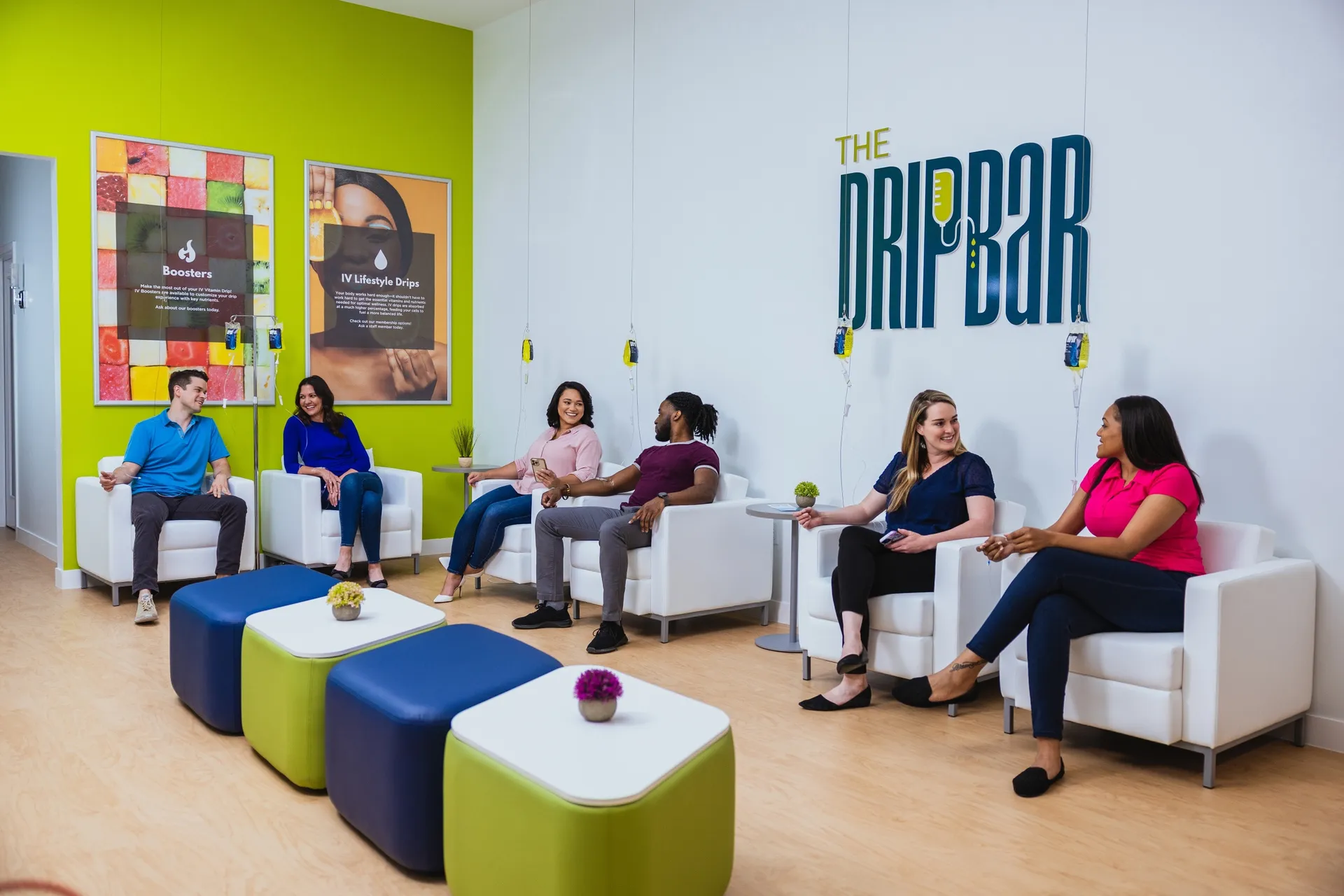 The DRIPBaR lounge with clients relaxing in white recliners under the logo