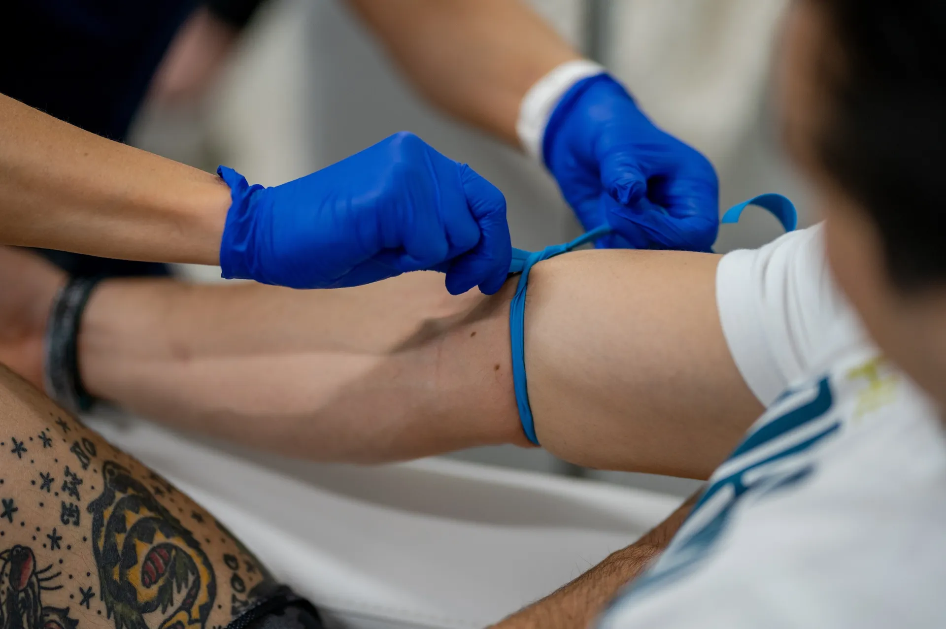 A nurse's gloved hands preparing an arm