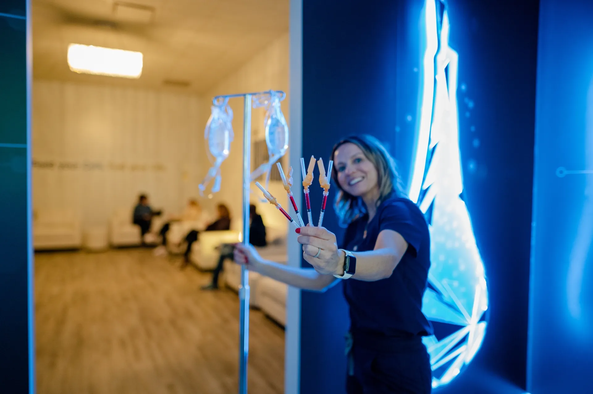 A nurse holding IM shots by the neon drop